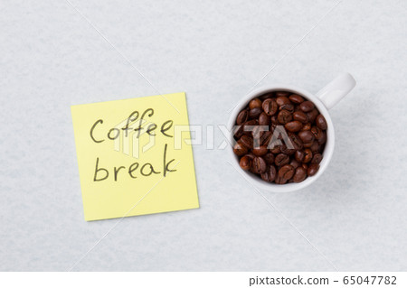 View from above on a cup with roasted coffee beans. View from above on a cup with roasted coffee beans. 65047782