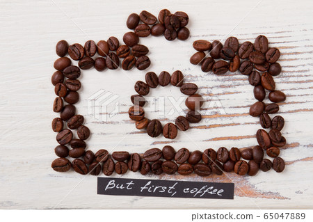 Roasted coffee beans arranged in a shape of photo camera. Roasted coffee beans arranged in a shape of photo camera. 65047889