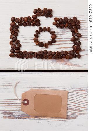 Photo camera of coffee beans and blank paper tag for copyspace. Photo camera of coffee beans and blank paper tag for copyspace. 65047890