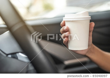 Woman hold paper cup coffee of hot in hand while Woman hold paper cup coffee of hot in hand while 65048097