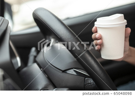 Woman hold paper cup coffee of hot in hand while Woman hold paper cup coffee of hot in hand while 65048098