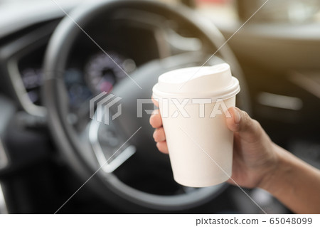 Woman hold paper cup coffee of hot in hand while Woman hold paper cup coffee of hot in hand while 65048099