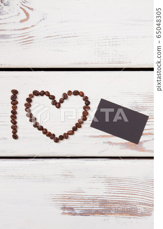 Heart frame shaped coffee beans and blank black paper. 65048305
