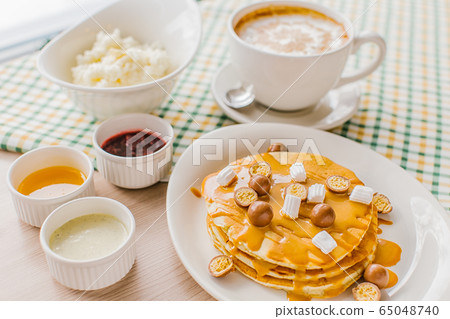 A breakfast with panckakes latte and rice porrige 65048740