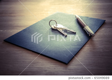 Keys, pen and envelope on the wooden table. Selling or rental of flat, house or another real estate or object. Symbol of agreement Keys, pen and envelope on the wooden table. Selling or rental of flat, house or another real estate or object. Symbol of agreement 65049089