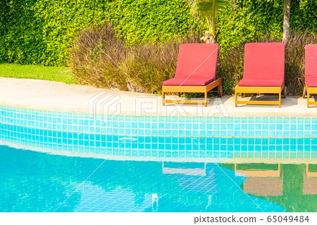 Beautiful empty chair around outdoor swimming pool in hotel resort 65049484