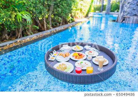 Floating breakfast set in tray with fried egg omelette sausage ham bread fruit milk juice coffee Floating breakfast set in tray with fried egg omelette sausage ham bread fruit milk juice coffee 65049486