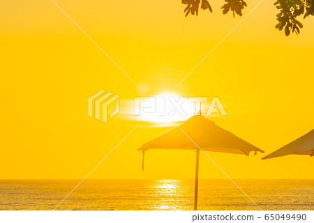 Beautiful tropical outdoor beach sea ocean with umbrella and chiar around outdoor swimming pool at sunset or sunrise time Beautiful tropical outdoor beach sea ocean with umbrella and chiar around outdoor swimming pool at sunset or sunrise time 65049490