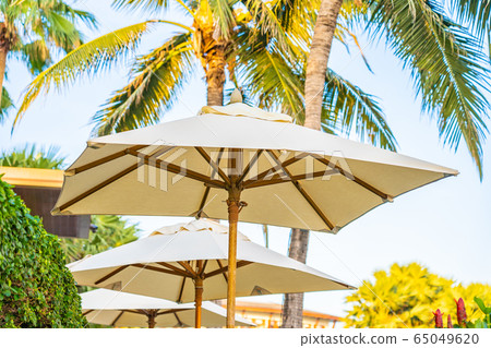 Umbrella and chair around outdoor swimming pool in hotel resort Umbrella and chair around outdoor swimming pool in hotel resort 65049620