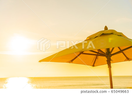 Beautiful tropical nature umbrella chair with palm tree around beach sea ocean at sunset or sunrise Beautiful tropical nature umbrella chair with palm tree around beach sea ocean at sunset or sunrise 65049663