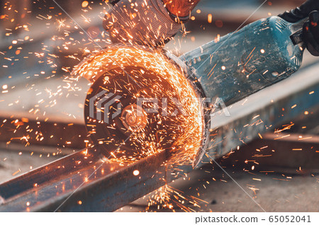 Construction worker using Angle Grinder cutting Metal at construction site. Construction worker using Angle Grinder cutting Metal at construction site. 65052041