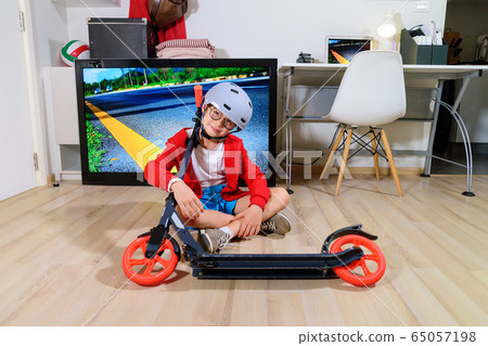 Boy imitating outdoor activities with kick scooter 65057198
