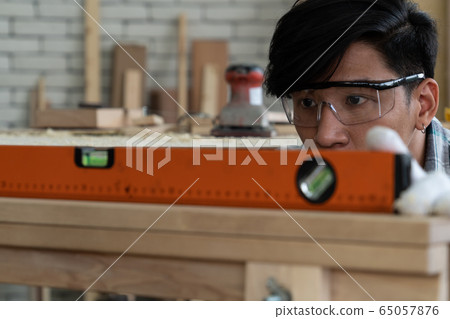 Carpenter working on wood craft at workshop 65057876