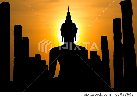 Buddha statues   with (effect) yellow background of the sun - Sukhothai Thailand  65058642