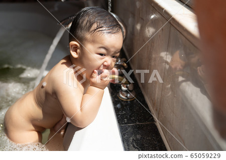Asian happy laughing baby boy taking a bath 65059229