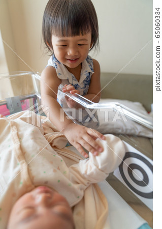 Asian little sister take care her newborn brother. 65060384