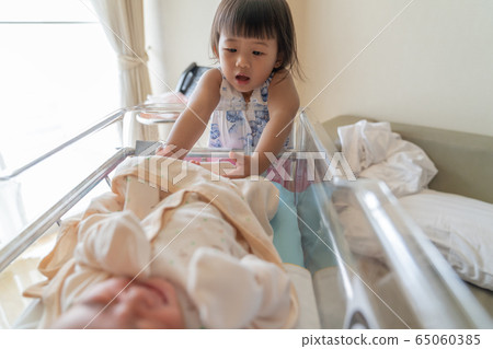 Asian little sister take care her newborn brother. Asian little sister take care her newborn brother. 65060385