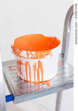Ladder with paint in bucket near color wall indoors. Renovation and redecoration concept. Ladder with paint in bucket near color wall indoors. Renovation and redecoration concept. 65061348