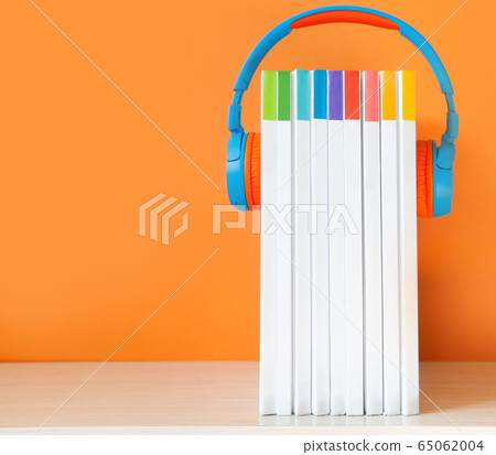 Colorful Headphones and books on color background. Concept of audiobook. 65062004