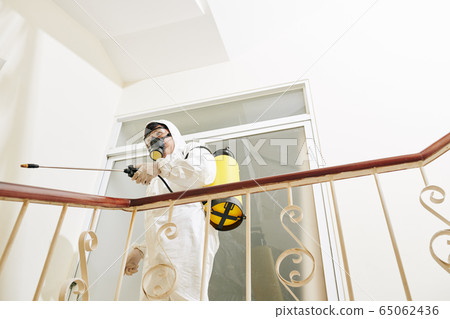 Cleaning service worker disinfecting stairs 65062436