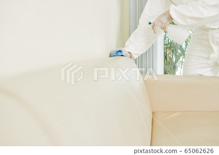 Cleaning service worker disinfecting furniture 65062626