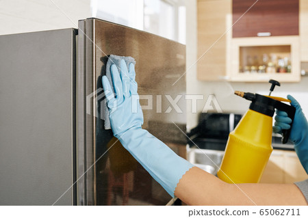 Woman cleaning refrigerator 65062711