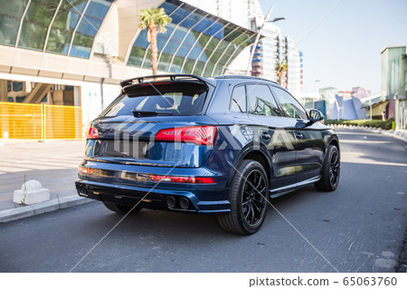 Blue sport offroader in a touristic city in front of a building 65063760