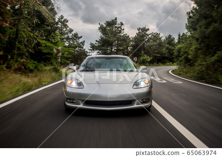 Silver supercar speed autoshow, empty highway,dark weather,front view 65063974
