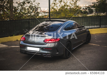 Blue sport car parked around a farming zone 65064110