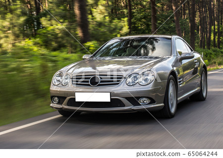 Silver racecar landscape drive in the sunset, front view Silver racecar landscape drive in the sunset, front view 65064244