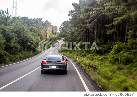 Grey color supercar motion in the rain forests Grey color supercar motion in the rain forests 65066637