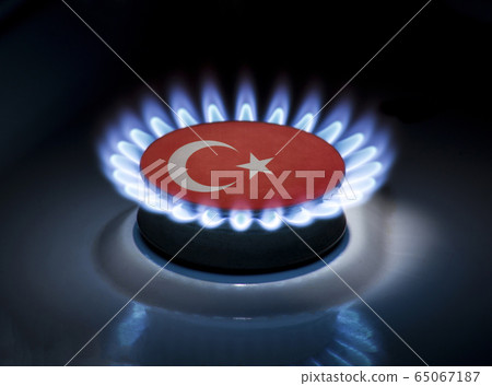 Burning gas burner of a home stove in the middle of which is the flag of the country of Turkey. Gas import and export delivery concept, price per cubic meter, transit, background Burning gas burner of a home stove in the middle of which is the flag of the country of Turkey. Gas import and export delivery concept, price per cubic meter, transit, background 65067187