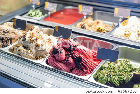 Selling delicious fresh ice cream by weight in a shop window, background 65067216