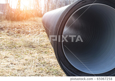 Large diameter black polypropylene pipes for laying communications, drainage systems and heating mains under the road. Modern method and technology for supplying water and sewage, copy space, industry Large diameter black polypropylene pipes for laying communications, drainage systems and heating mains under the road. Modern method and technology for supplying water and sewage, copy space, industry 65067258