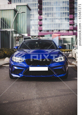 Blue design racing car parking outside of a business building 65067271
