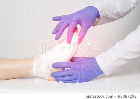The doctor examines the little finger on the toe. The concept of applying gypsum to the toe, fracture of the foot with displacement, medic The doctor examines the little finger on the toe. The concept of applying gypsum to the toe, fracture of the foot with displacement, medic 65067282
