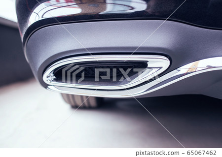 New modern chrome tailpipe on a black passenger car. Tuned muffler and beautiful bumper, transportation New modern chrome tailpipe on a black passenger car. Tuned muffler and beautiful bumper, transportation 65067462