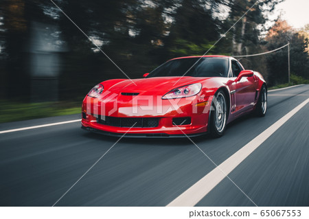 Red sport sedan on the road 65067553