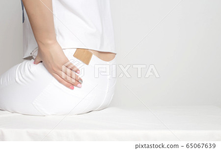 A girl in white clothes holds by the hip in which pain and inflammation. Femur Osteoarthritis Concept, copy space A girl in white clothes holds by the hip in which pain and inflammation. Femur Osteoarthritis Concept, copy space 65067639