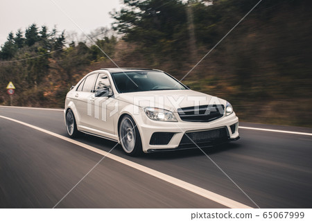 White sport sedan on the highway. High speed drive. Front view White sport sedan on the highway. High speed drive. Front view 65067999