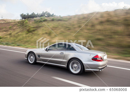 Silver chasing car on the mountain road, across farmlands Silver chasing car on the mountain road, across farmlands 65068008