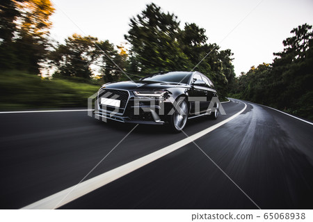 Black hatchback speed drive on the highway 65068938