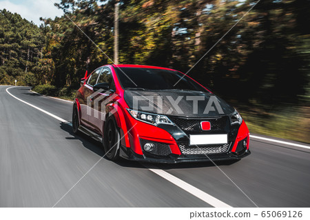 Black modern supercar with bordeaux roof in the forest,speed motion Black modern supercar with bordeaux roof in the forest,speed motion 65069126