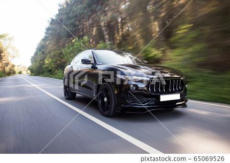 Black chasing car landscape drive in the forest,front view 65069526