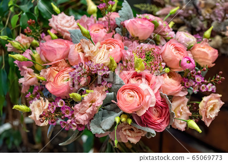 Close-up of beautiful multi-colored bouquet of mixed roses and other flowers in a shop. Fresh cut flowers Close-up of beautiful multi-colored bouquet of mixed roses and other flowers in a shop. Fresh cut flowers 65069773