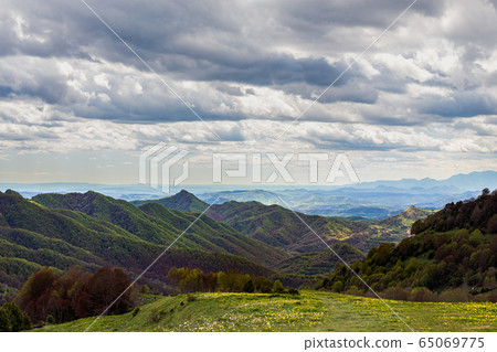 Green mountain peaks with heavy clouds. Forest and green meadow in the foreground. Catalunya, Spain Green mountain peaks with heavy clouds. Forest and green meadow in the foreground. Catalunya, Spain 65069775