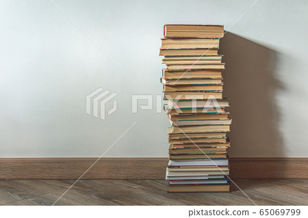 Big stack of old books over white wall 65069799