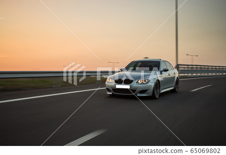 Silver offroader performance test drive in the sunset on the empty highway 65069802