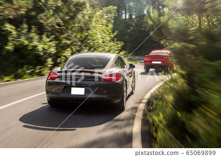 Sport supercars racing on the forest road in a daytime,driving curved roads Sport supercars racing on the forest road in a daytime,driving curved roads 65069899