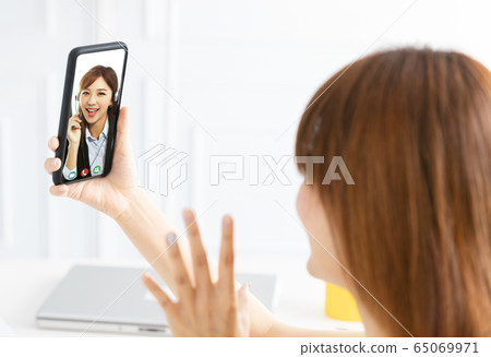 young woman working at home and using mobile phone young woman working at home and using mobile phone 65069971